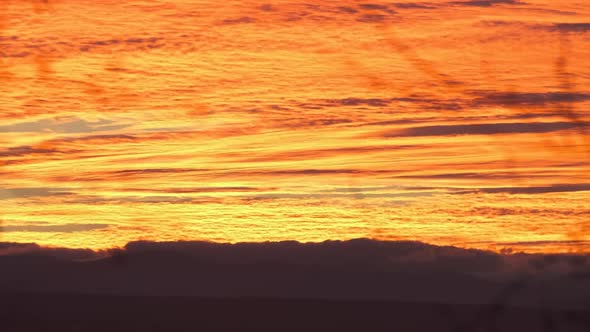 Bright Colorful Sunset Sky with Vivid Smooth Clouds Illuminated with Setting Sun Light Spreading to