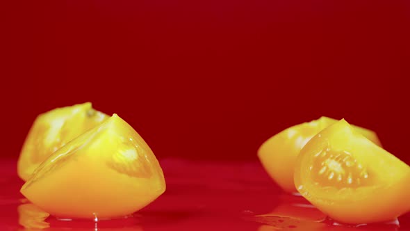 Set of Video Shots Ripe Yellow Tomato Slices Falling on Wet Reflective Table Surface