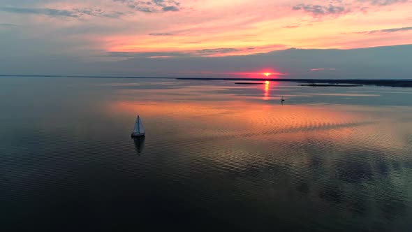 Aerial Drone Footage of Peaceful Scene with Yacht Cruising at Calm Water at Dusk