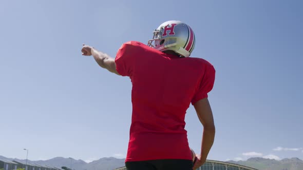 American football player standing with arm raised