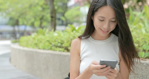 Woman typing on cellphone in the city