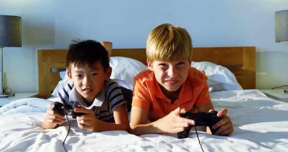 Siblings playing video game in bedroom