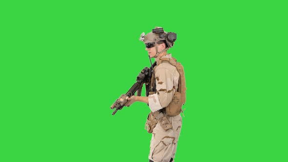 Soldier Aiming with an Assault Rifle on a Green Screen, Chroma Key.