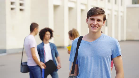Student Smiling at Camera By College