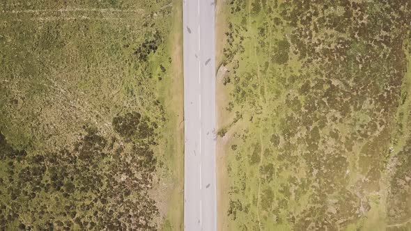 Overhead view of the road cutting through the Dartmoor National Park farm land. Green fields next to