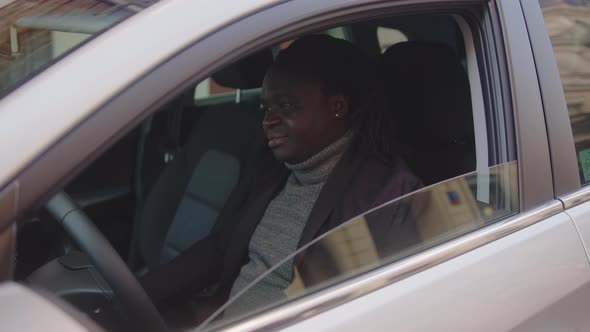 African American Black Man Showing Car Key and Thumb Up While Sitting in His New Car