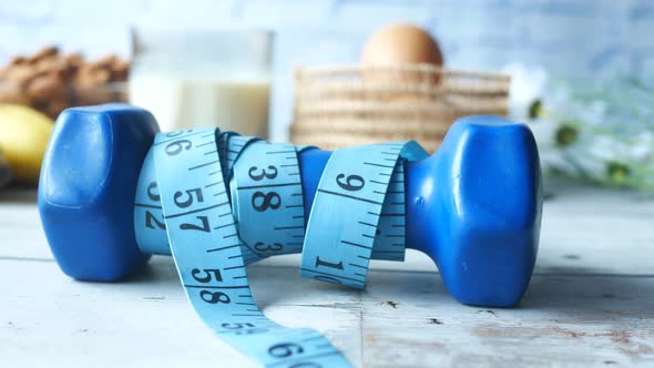 Dumbbell with Measurement Tape Almond Nut Egg Banana on Table