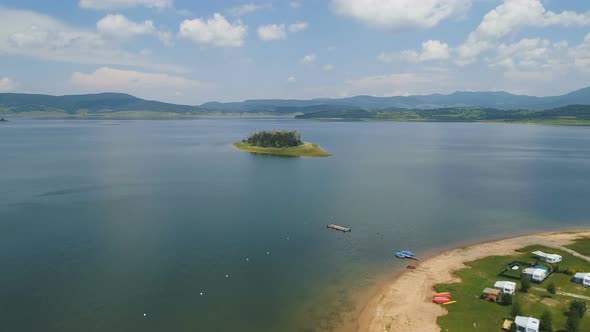 View of Lake Island and Lake Shore with Cloudy Sky in The Background