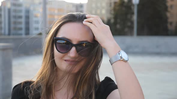 Portrait of Young Businesswoman in Sunglasses with Cityscape at Background