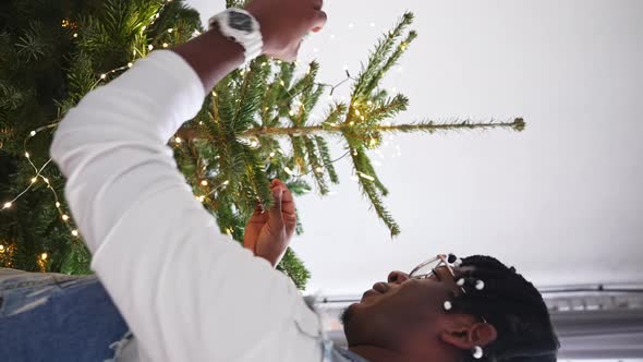 AfricanAmerican Middleaged Man Decorating Christmas Tree