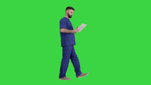 Confident Concentrated Focused Surgeon Using Digital Tablet on a Green Screen, Chroma Key.