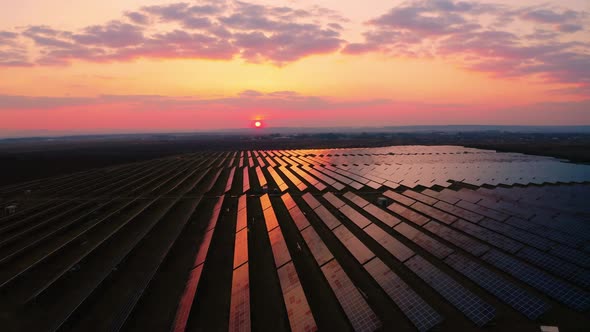 Aerial view of Solar Power Station Panels in Germany. Flyover Fields Green Energy at Sunrise.