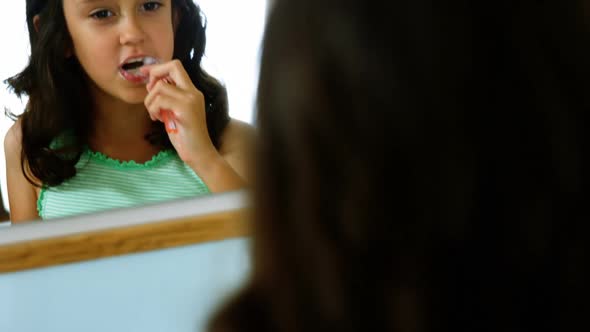 Girl brushing her teeth in bathroom