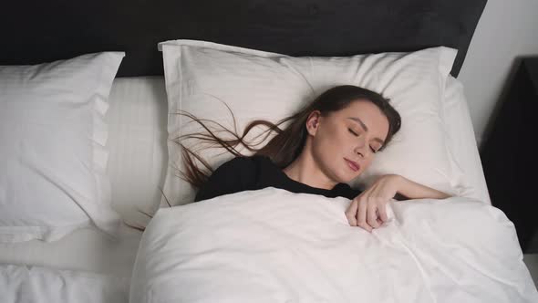 Close Up Portrait of Relaxed Woman Sleeping on a White Pillow in Bed