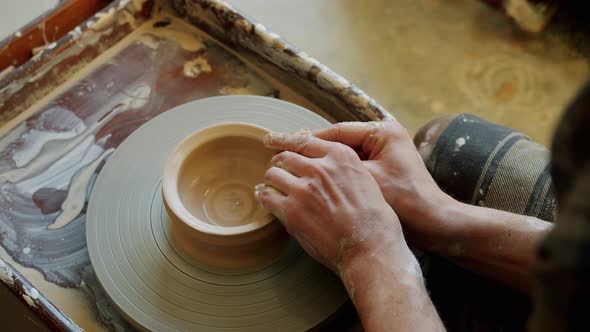 Close-up of Young Man's Hands Molding Clay Into Ceramic Bowl on Throwing Wheel