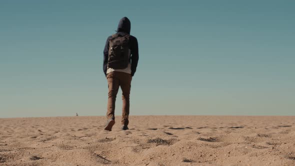 Man Walking Alone in the Sunny Desert Near Dubai Backpack Tourist Alone