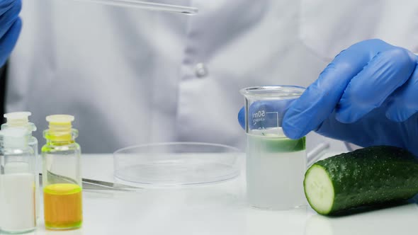 Scientist Mixing Cucumber in Solution Taking It Out in Dish Looking at Vegetable with Magnifying