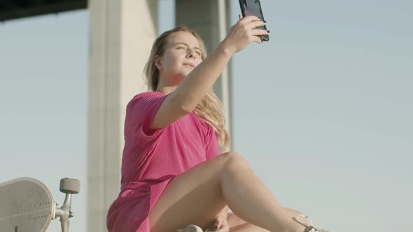 Cute Girl Taking Selfie on Phone After Skateboarding in Park