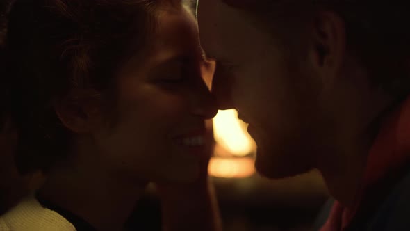 Smiling Lovers Kissing Together Resting at Fireplace