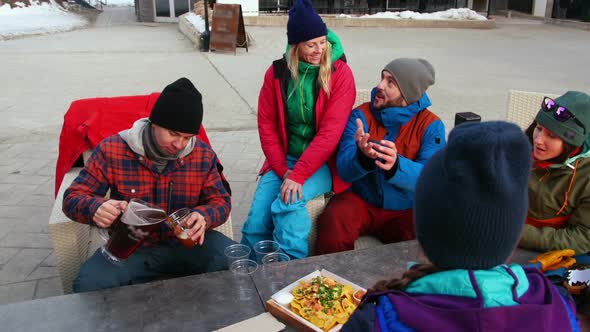 Friends having snacks near campfire