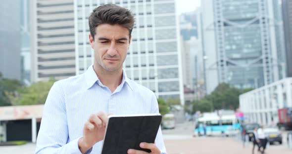 Businessman use of tablet outside office
