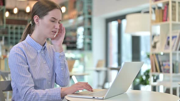 Young Businesswoman with Headache Using Laptop in Cafe
