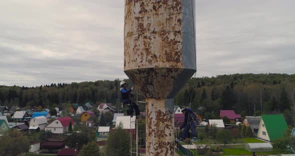 Industrial Climbers Paint the Iron Tower. Risky Job. Extreme Work. Worker Alpinist.