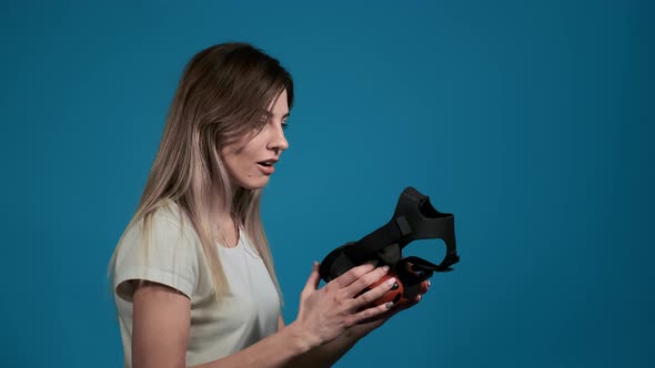 Surprised Woman in T-shirt Looks at Virtual Reality Headset