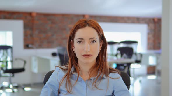 Redhead Businesswoman Celebrating Great News at Work