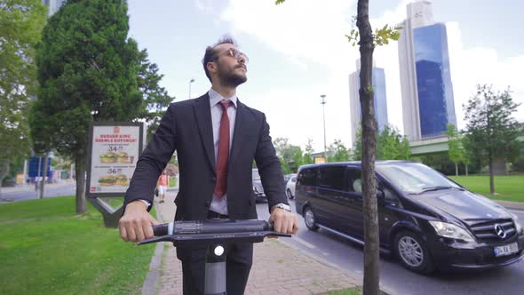 Low Angle View Of Young Man Riding Electric Scooter In The City.