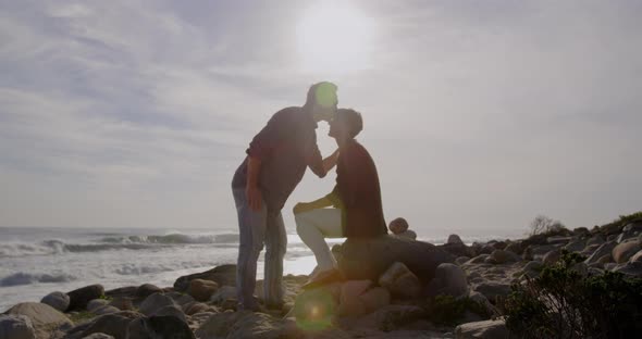 Caucasian couple enjoying free time by sea on sunny day, man kissing