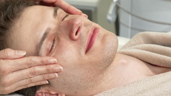 Cropped Shot of a Happy Man Enjoying Head and Face Massage at Spa Center