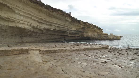 Il-Kalanka Beach in Malta with Splashing Water on Steep Limestone Hill