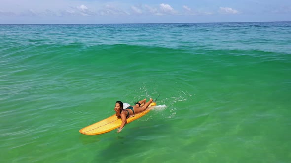 4K Aerial view of Asian woman surfing in the sea