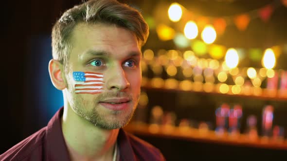 Nervous American Soccer Fan With Flag on Cheek Unhappy With Game Result