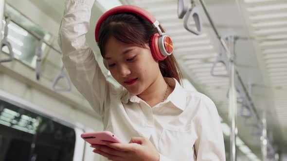 Young Woman Using Mobile Phone on Public Train