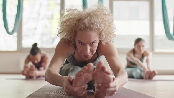 Blonde Woman Stretching in Yoga Class
