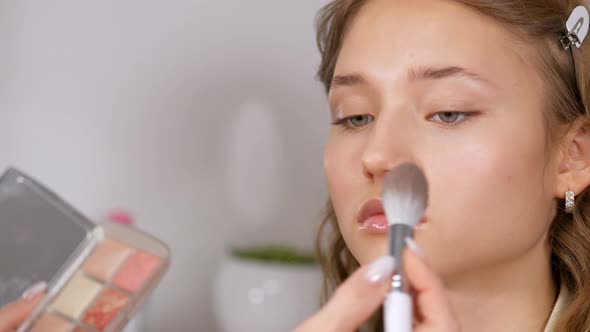 Preparing the Model's Skin for Applying Makeup. Processing the Face with a Brush with a Powder