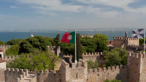 Closeup of National and Municipal Flags on Poles Over Medieval Stone Saint George Castle