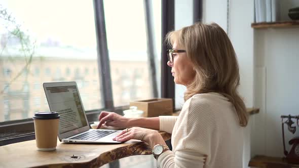 Woman Journalist Sit in Cafe with Laptop and Type Write an Article Text