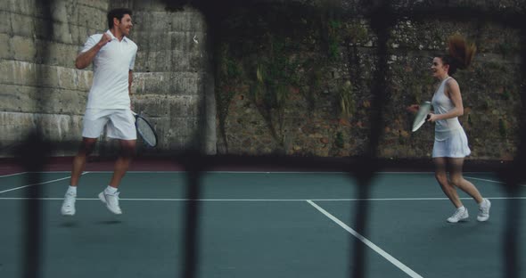 Woman and man playing tennis on a court