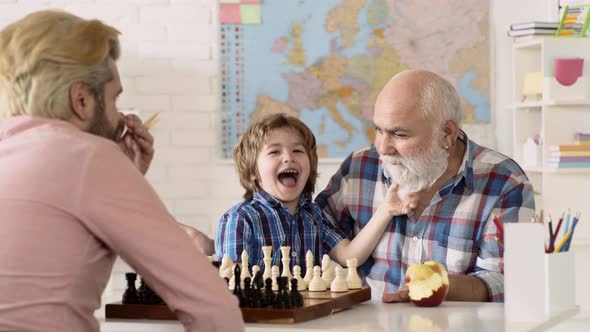 Father, Grandfather and Son Playing Chess at Home. Games and Activities for Children. Family Concept