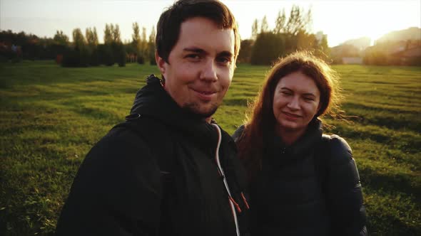 Young Happy Man and Woman Making Selfie Outdoor Strong Back Light Slow Motion