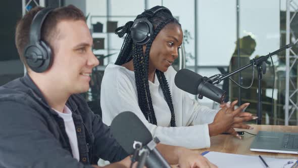 Confident African American Woman With White Man Hosting a Podcast
