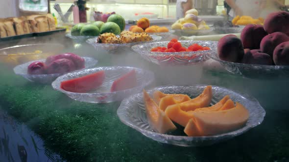 Fresh Sliced Fruits on the Plates on a Market Showcase