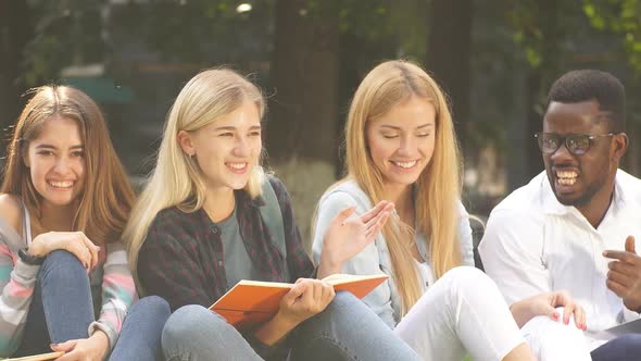 Mixed-race Group of Students Sitting Together on Green Lawn of University Campus