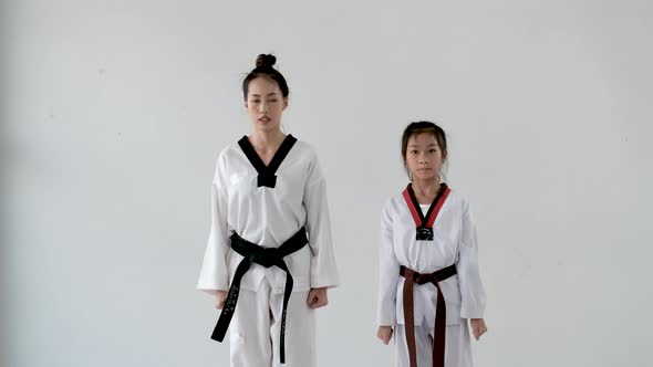 Taekwondo teacher and student woman and girl stand for prepare of saluting