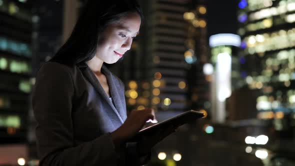 Woman use of mobile phone in the city at night 