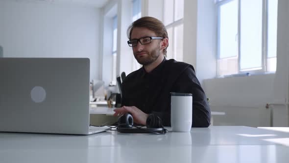 Man in Glasses Looks on Laptop's Screen but Can't Work