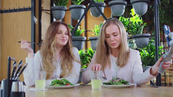 Pretty Ladies Eating Fresh Salads and Filming on Smartphone